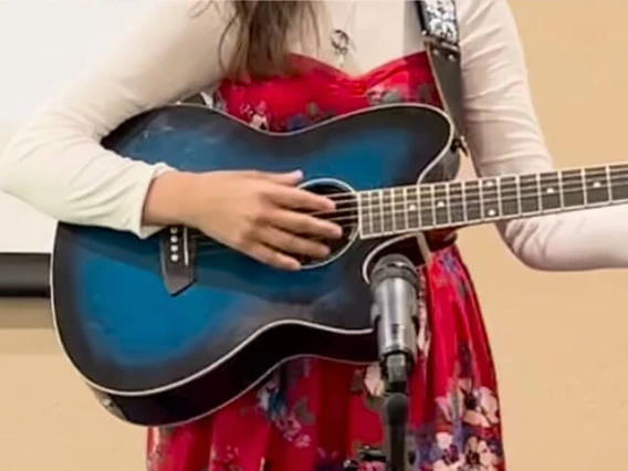 Girl in red dress playing a blue guitar