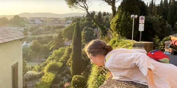 Woman leaning over a wall for a view of Orvieto