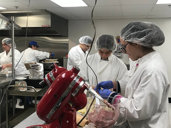 Italian students cooking in kitchen