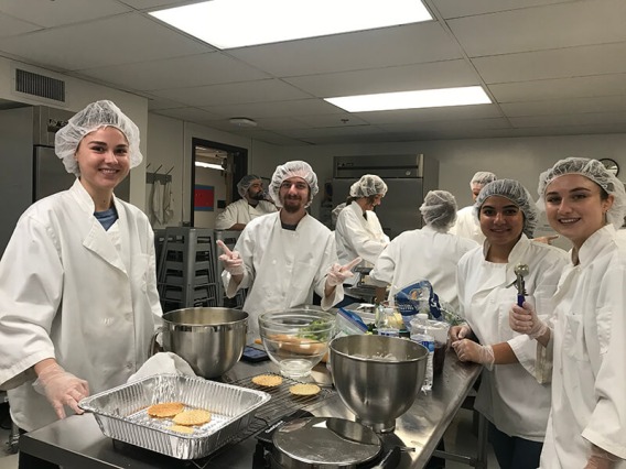 Italian students in kitchen smiling to camera