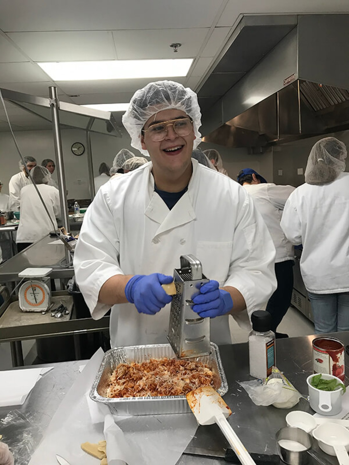 Italian student grating parmesan cheese