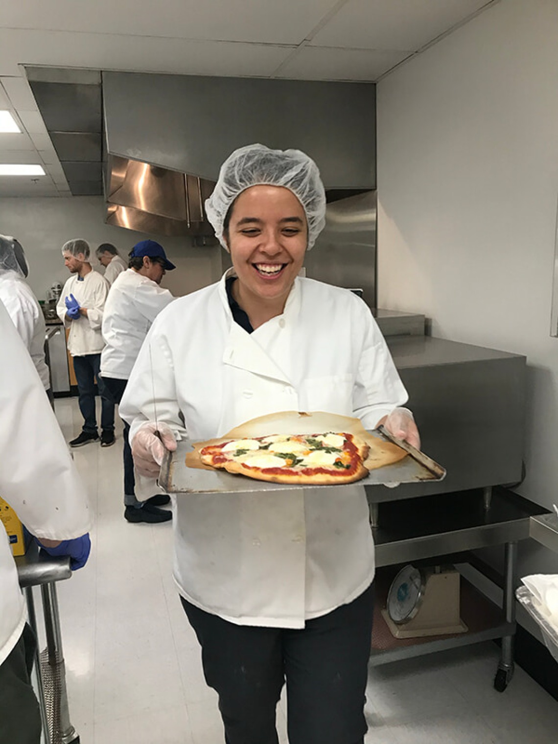 Italian student holding homemade pizza