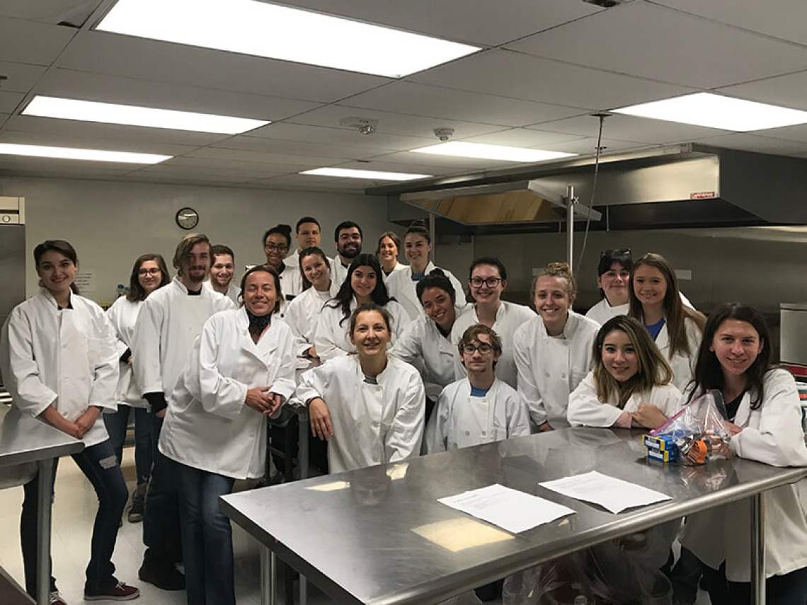 Group photo of Italian students and faculty in the kitchen