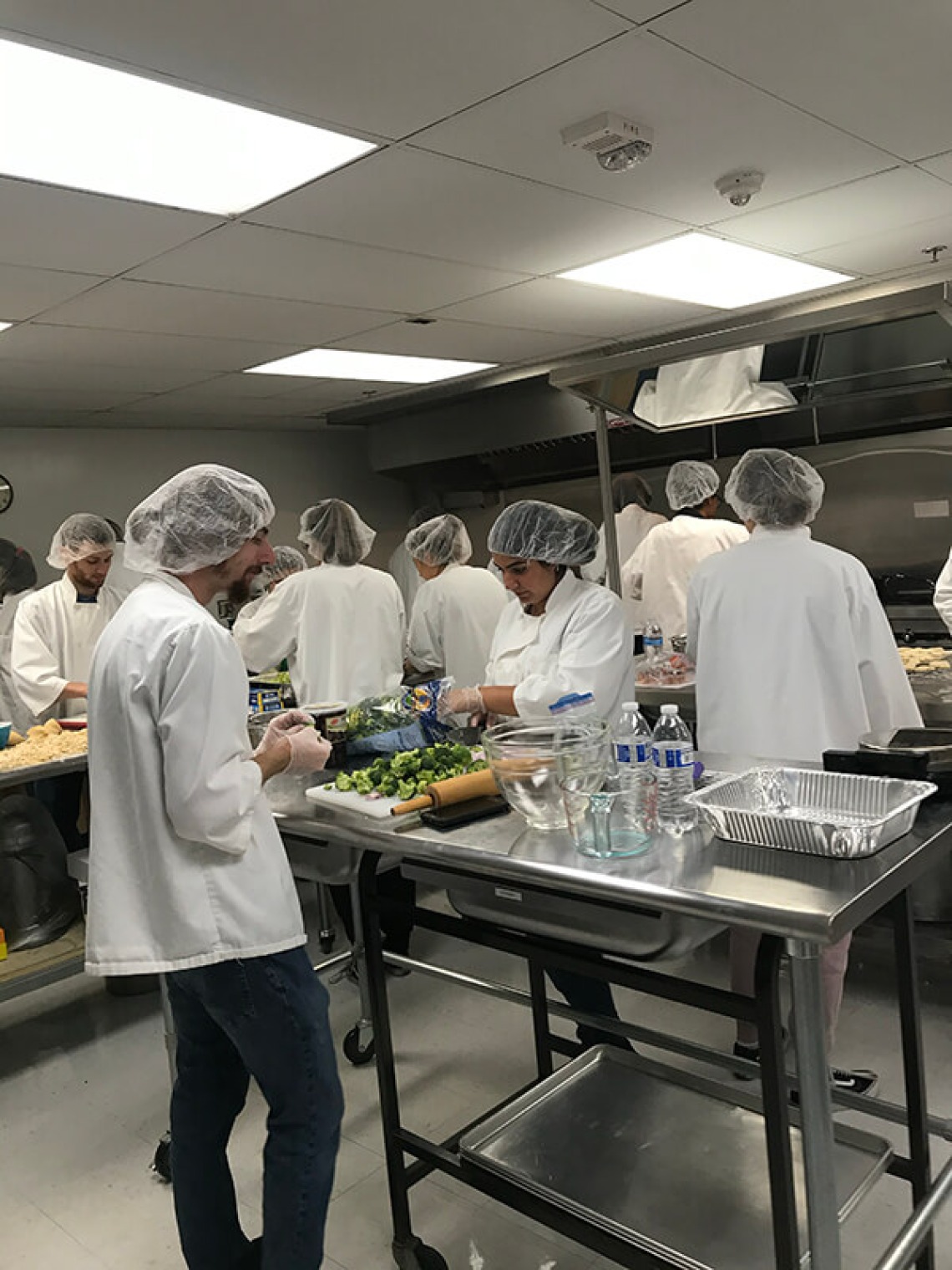 Students busy cooking at different kitchen stations