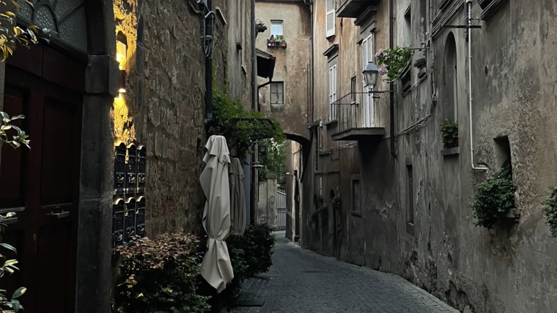 Photo of a narrow cobbled walkway between residences in Italy